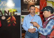 Dominic Garnazzo with Wada Farms is talking with a show attendee.